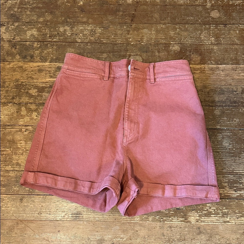 burnt orange/coral shorts.